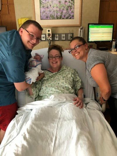 Tamara smiling with couple and baby in hospital
